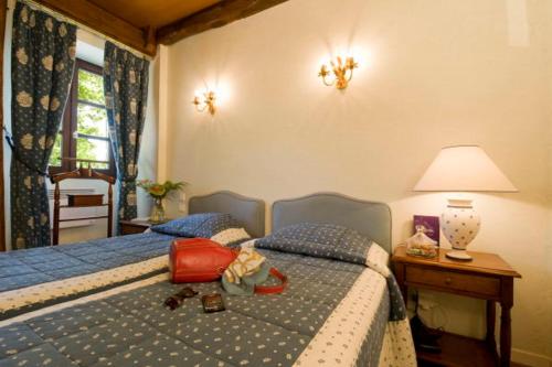 a bedroom with two beds and a table with a lamp at Resort Golf Château de Salles in Vezac