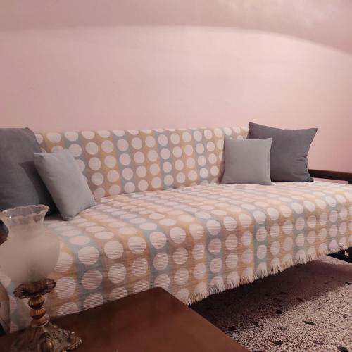 a couch with pillows on it in a room at The Vintage House in Nea Moudania