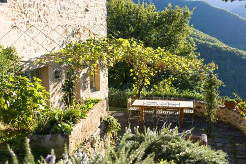a table and chairs in a garden with a mountain at Romantic Apartment With Tuscan Valley Views in Londa