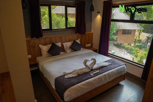 a bedroom with a bed with two swans on it at Nvoyages Wayanad in Wayanad