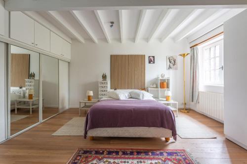 a bedroom with a bed with a purple bedspread at La Ruche - Maison 7p avec Jardin in Saint-Lucien