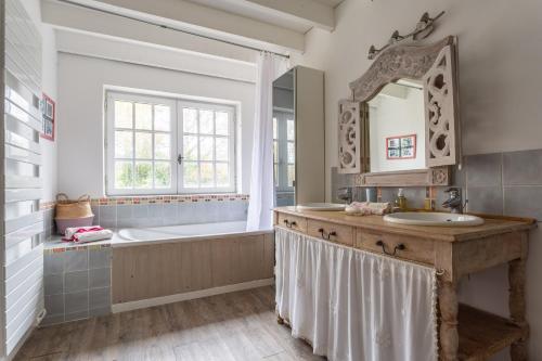a bathroom with a tub and a sink and a mirror at La Ruche - Maison 7p avec Jardin in Saint-Lucien