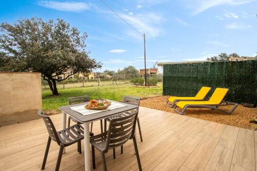 a patio with a table and chairs on a deck at Mas Pigem in Pals