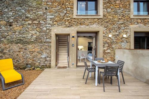 a patio with a table and chairs in front of a building at Mas Pigem in Pals