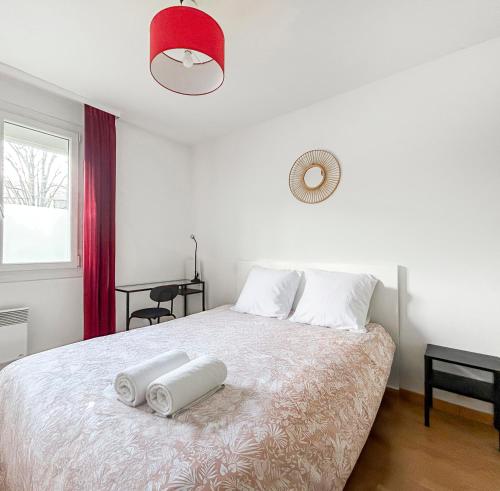 a bedroom with a bed with two towels on it at La forêt, T3 Design, Parking, Face à la Gare in Grenoble