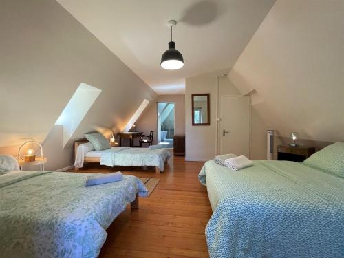 a attic bedroom with two beds and a table at Paillé in Artiguelouve