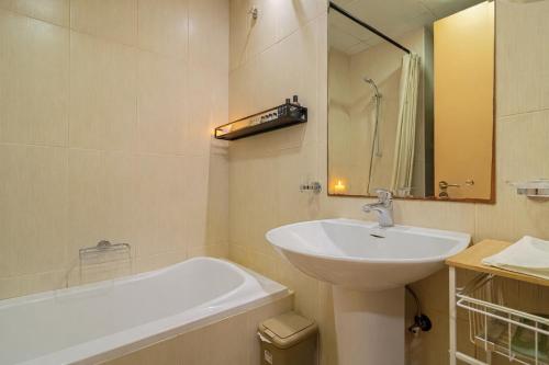 un baño blanco con lavabo y bañera en The Sandstone Studio, en Ras al Khaimah