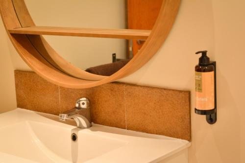 a bathroom sink with a mirror and a soap dispenser at Mas Salvador Rural Experience in Llagostera