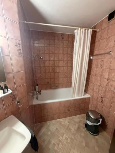 a bathroom with a tub and a toilet and a sink at Appolo in Vouvry