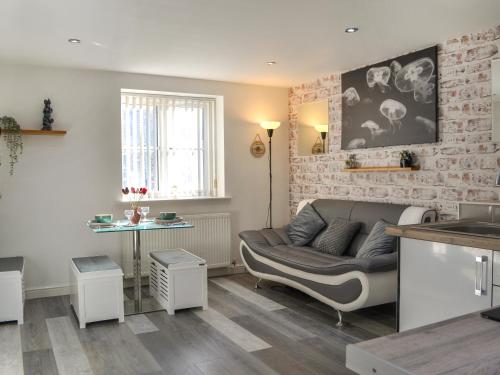 a living room with a couch and a brick wall at Holly's Apartment in Beverley