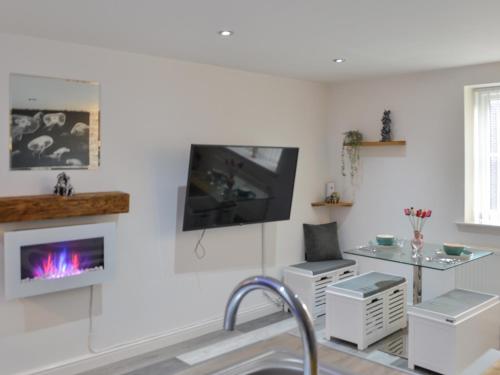 a living room with a fireplace and a tv at Holly's Apartment in Beverley