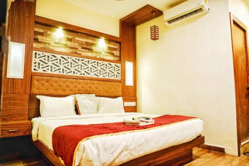 a bedroom with a large bed with a red blanket at Qubehotelinn in Cochin