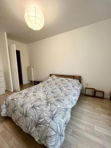 a bedroom with a bed and a light at Villeneuve, in Villeneuve d'Ascq