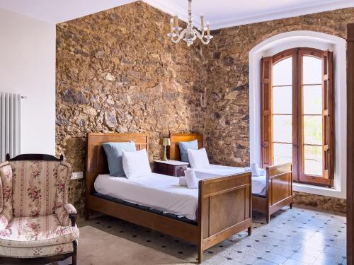 a bedroom with a bed and a chair at Majordoms - Castell de Villavecchia - 33 pax in Sant Hilari Sacalm