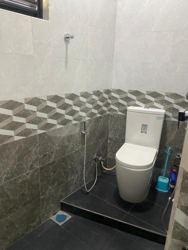 a bathroom with a toilet in a tiled room at Chandani Hostel in Galle