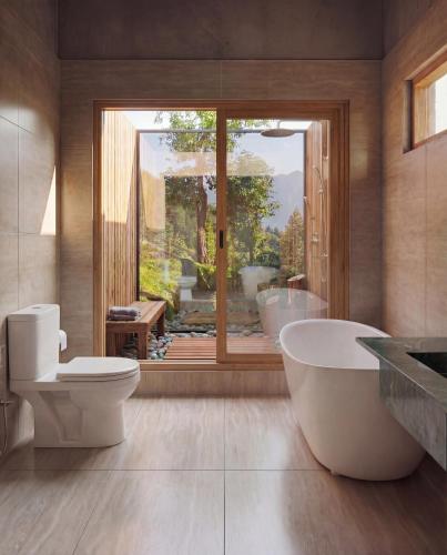 a bathroom with a tub and a toilet and a window at Semari Resort in Muzaffarabad