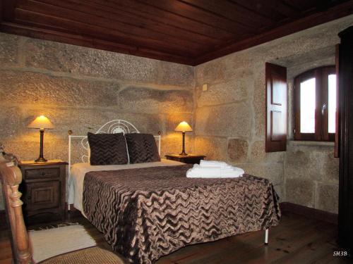 a bedroom with a bed and two lamps and a window at Casa Do Pomar in Parada