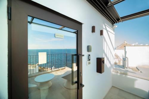 a door to a balcony with a view of the ocean at Le Contrade Di San Salvatore in Monopoli