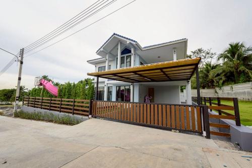 a house with a wooden fence in front of it at BanIngKhao Pool Villa Sriracha in Ban Hup Bon