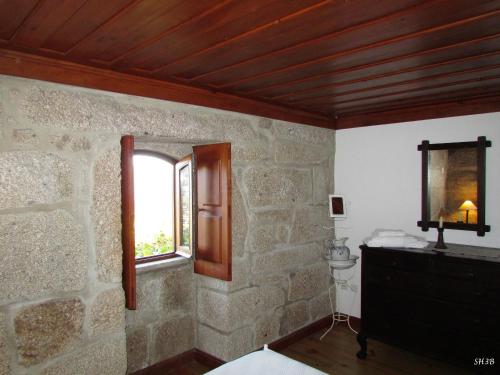 a room with a stone wall and a window at Casa Do Pomar in Parada