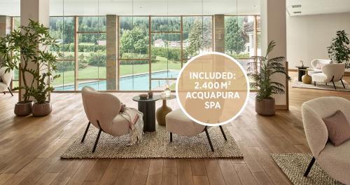 a room with chairs and a table and a sign at Falkensteiner Hotel & Spa Carinzia l 4 Star Superior in Tröpolach