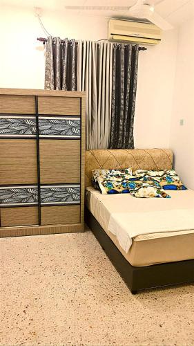 a bedroom with a bed and a dresser at A K Homestay in Sungai Petani
