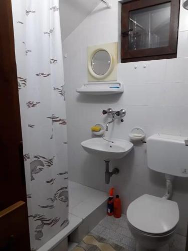 a bathroom with a toilet and a sink at Vacation home in Virpazar
