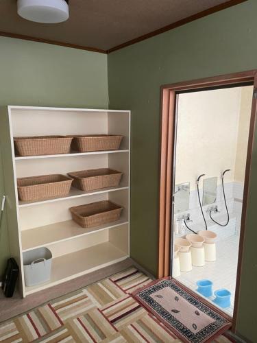 a bathroom with a shower with baskets and a window at ペンション愛宕道 in Kyoto