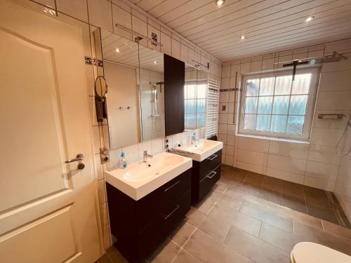 a bathroom with two sinks and a large mirror at Ferienwohnung Dietje in Stedesdorf