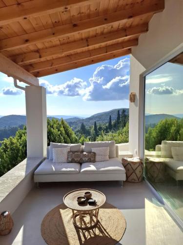 a living room with a couch and a large window at Villa Kalivista in Spartýlas