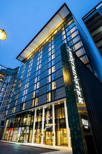 a tall glass building with a sign in front of it at Riu Plaza London The Westminster in London