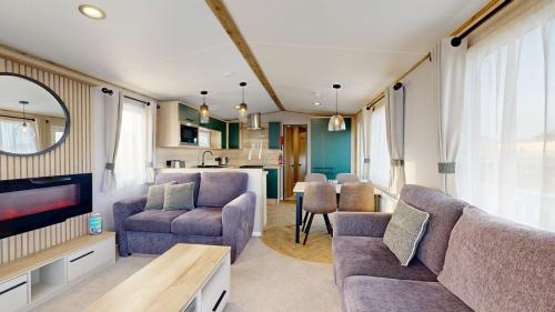 a living room with a couch and chairs and a table at Unity Beach in Berrow