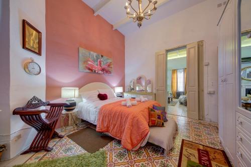 a bedroom with a bed and a chandelier at Charming Central 2BR Townhouse with Rooftop Terrace in St. Julianʼs