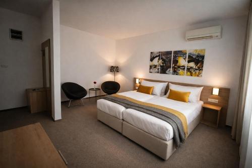a hotel room with a bed and two chairs at Hotel Kapitol in Most