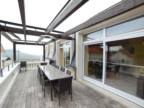 a patio with a table and chairs on a deck at VOIRIN Valérie in Cramant