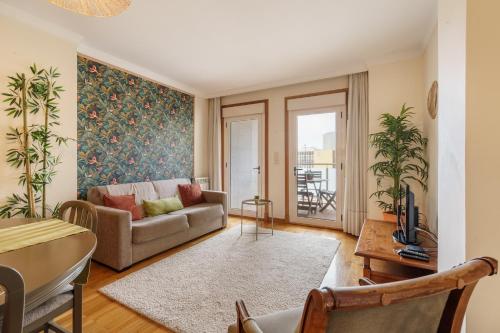 a living room with a couch and a table at Sunny Beachside Escape by Minho's Guest in Póvoa de Varzim