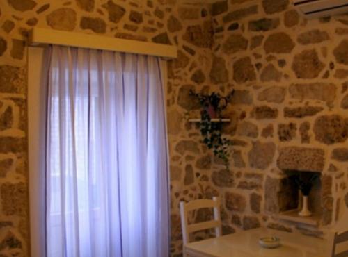 a room with a window with a table and a stone wall at Menego Lodge Bol in Bol