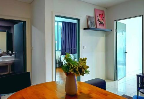 a vase of flowers sitting on a wooden table at STAR Hotel Apartment in Kuala Lumpur