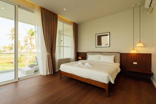 a bedroom with a bed and a large window at PRAN MARE Pranburi in Ban Nong Ban Kao