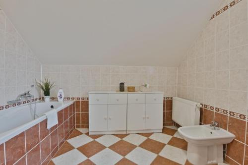a bathroom with a toilet and a tub and a sink at Chalupa u golfu Kořenec in Kořenec