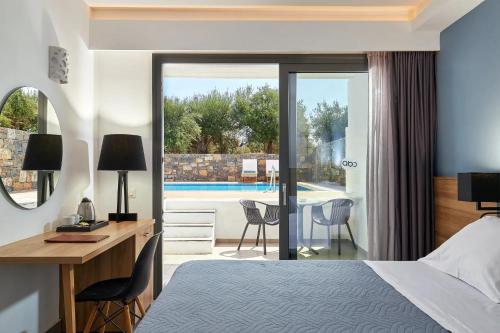 a hotel room with a bed and a desk and a view of a pool at Sentido Amounda Bay in Amoudara Herakliou