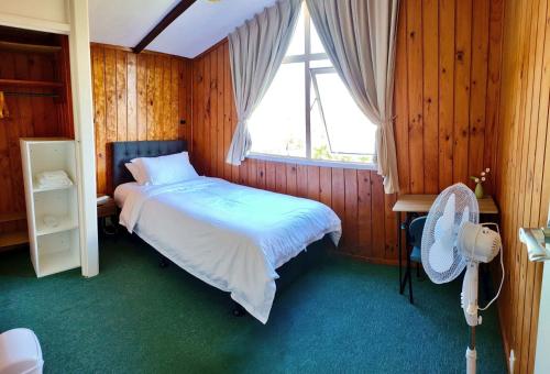 a bedroom with a bed and a window at Comfortable stay in Auckland