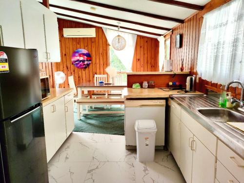 a kitchen with white cabinets and a black refrigerator at Comfortable stay in Auckland
