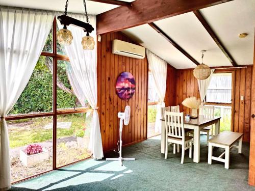 a dining room with a table and a window at Comfortable stay in Auckland