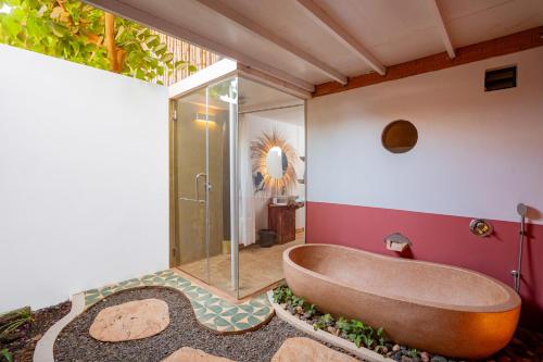 a bathroom with a tub and a shower at Kampung Kamboja in Phum Pobos