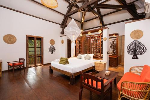 a bedroom with a bed and a table and chairs at Kampung Kamboja in Phum Pobos