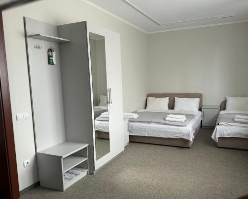 a bedroom with a mirror and a bed and a bed at Ресторан-Готель Шеркерт in Berehove
