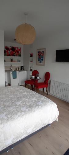 a bedroom with a bed and a red chair and a table at The Snug in Naas