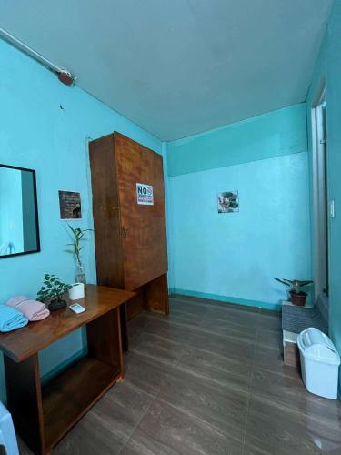a room with a desk and a blue wall at Cebu - Victoria's Guest House in Badian