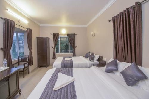 a hotel room with two beds and a window at Mounts shelts in Munnar